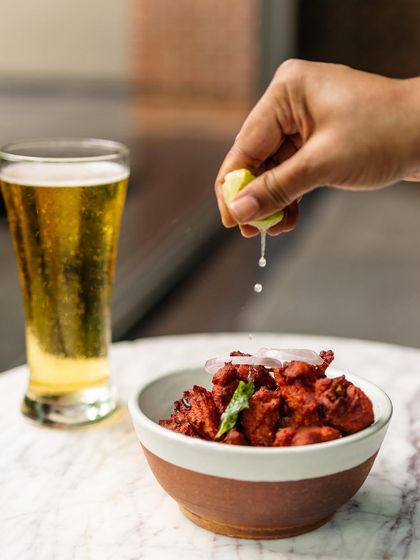 Our menu features plenty of 'touchings' or bar snacks that pair perfectly with a cold beer or a cocktail. This spicy chicken starter with a squeeze of lime is a crowd favorite at the Coracle bar.