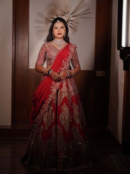 The full look, a picture of modern bridal elegance. The red lehenga is a classic choice, and the makeup is perfectly matched.