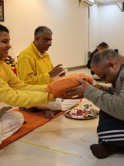A student bows in reverence as he receives his initiation materials, accepting his place in the lineage.