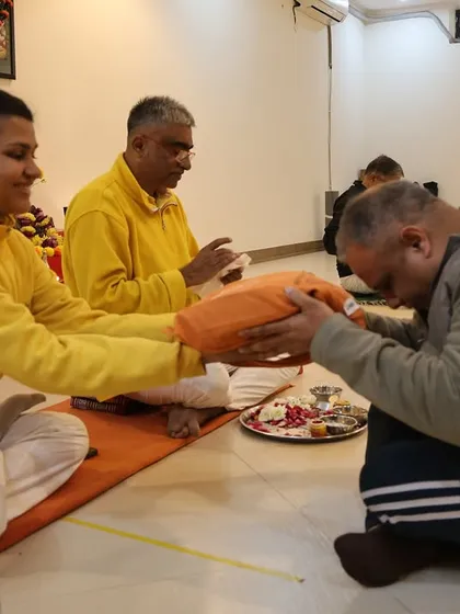 A student bows in reverence as he receives his initiation materials, accepting his place in the lineage.