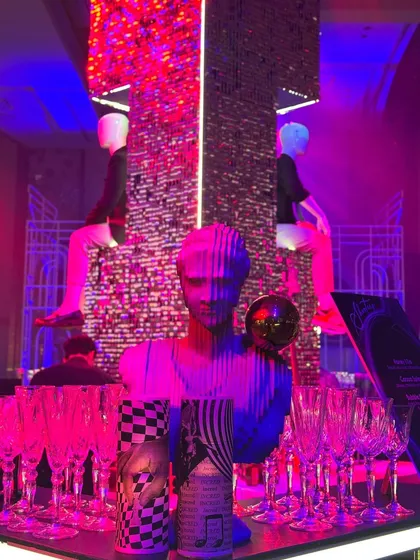 A detail from the funky bar. A mannequin bust and checkerboard-print candles add to the eclectic and artistic vibe of this unforgettable party. 🪩🩷