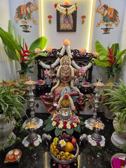 A beautifully decorated home shrine for Varamahalakshmi, with the Goddess in a lovely silk saree.