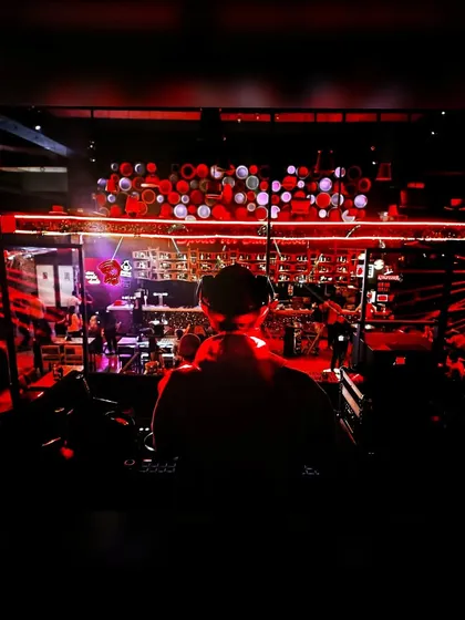 A silhouette shot of me against the red lights of the club. This captures the mood and atmosphere of a late-night DJ set.