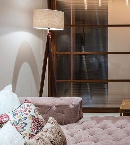 A closer look at the details in the Terrazzo Residence den, where a tripod floor lamp provides warm reading light next to the plush daybed.