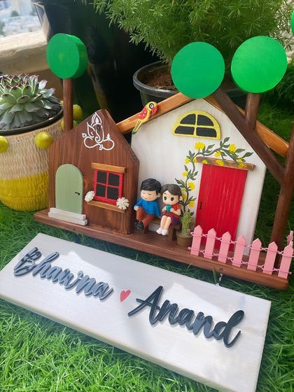 This is another look at one of my most popular designs, set against a lush green background. The contrast between the natural wood grain, the white painted house, and the bright red door really stands out. The hanging name board is ready for your family's names.