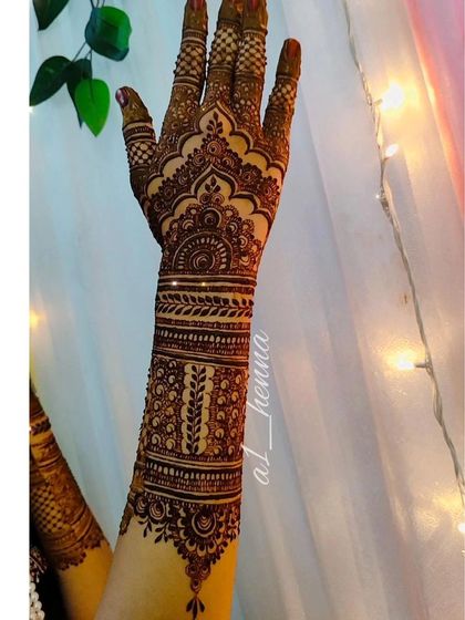 A detailed design covering the back of the hand and extending up the arm.