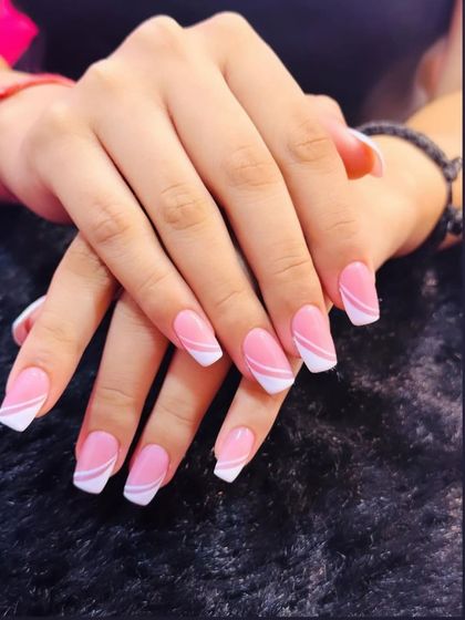A playful twist on the classic pink and white French manicure. This design features clean, graphic white lines on a pink base for a modern and stylish look.