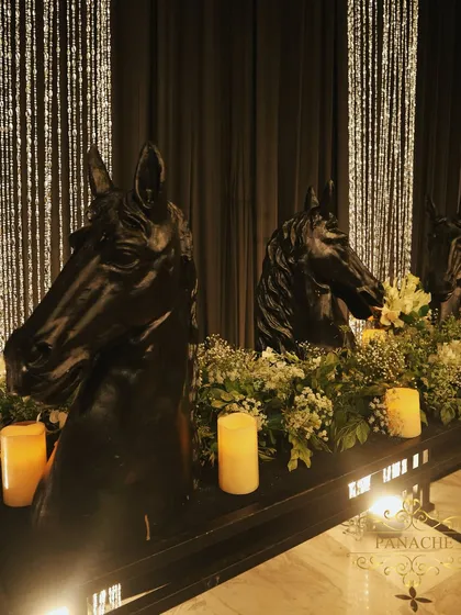 A unique decor element: a console table featuring black horse-head sculptures, surrounded by baby's breath and candles. This added a touch of regal, masculine energy to the design.