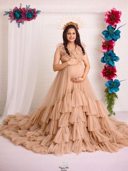 A regal portrait of the mom-to-be in our ruffled beige gown. The halo-like headpiece adds a unique, artistic touch to this maternity photo.