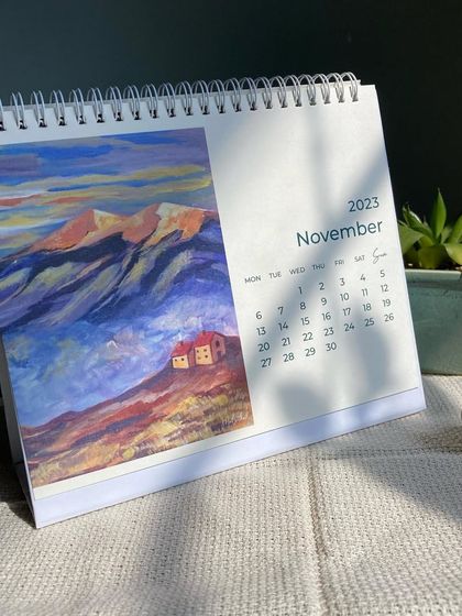 The November page of my calendar, featuring a colorful acrylic painting of mountain houses under a dramatic sky. This small-batch calendar is a great way to own a collection of my landscape art.