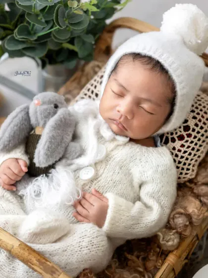 The little pom-pom hat just adds to the cuteness. This close-up shot highlights the delicate features of a newborn, from their soft skin to their tiny hands, all while they dream away.