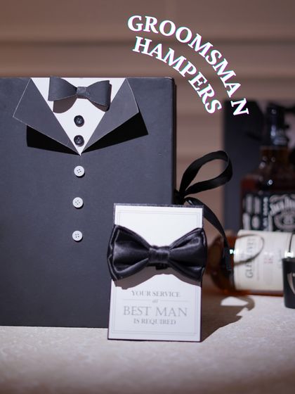 For the men, I design classic groomsmen proposal boxes. This tuxedo-style box comes with a "Your service as Best Man is required" card, setting a fun and formal tone.