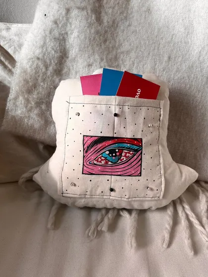 The back of the mood pillow, featuring a small pocket holding illustrated 'reassurance' cards.