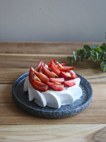 A side view of our Eggless Strawberry Feta Cheesecake, showcasing the beautiful piping work and the fresh strawberry topping. It's a guilt-free indulgence.