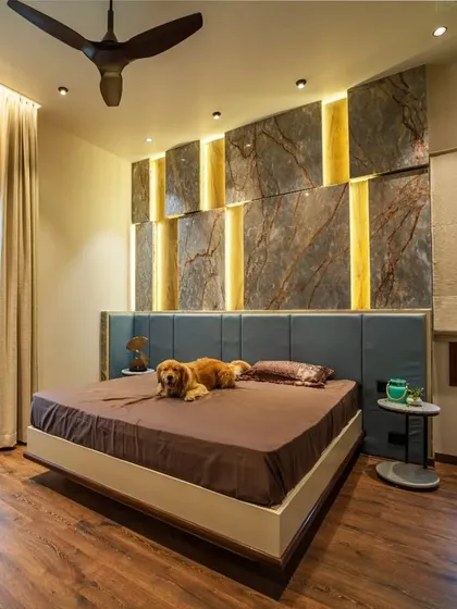 The son's bedroom in the "Vertical Nest" project, featuring a backlit stone-paneled wall and a comfortable bed that even the family dog, Leo, loves.