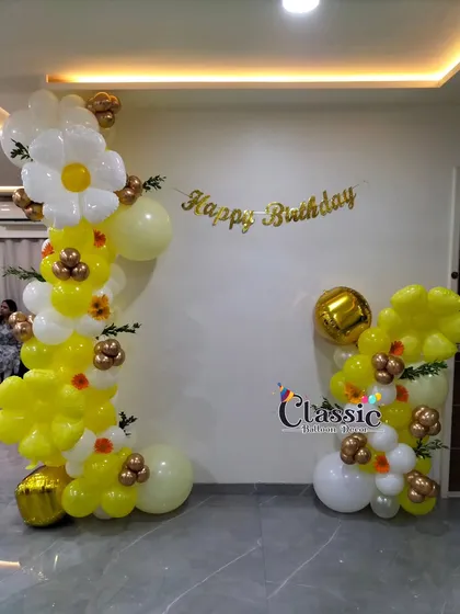 We can create decorations based on specific themes, like this lovely sunflower theme. The setup uses yellow and white balloons twisted into daisy and sunflower shapes, perfect for a bright and cheerful birthday party.