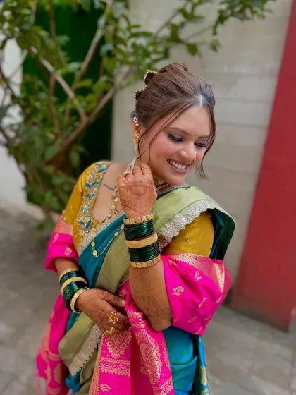 The bride's smile is infectious. Her makeup is designed to be soft and radiant, enhancing her natural beauty and happiness.