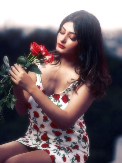 A classic, romantic portrait. The soft lighting and her interaction with the roses create a timeless and beautiful image.