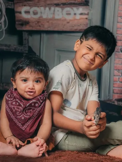 Brotherhood in action! Capturing the playful and mischievous dynamic between two brothers during a fun, cowboy-themed sibling photoshoot.