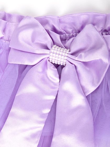 A close-up of the large satin bow with a pearl center on a lavender tutu.