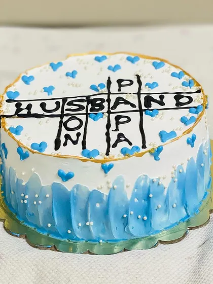 A creative crossword-style cake celebrating a husband, papa, and son.