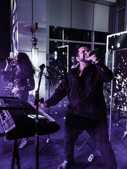 The full band on a rooftop stage, surrounded by atmospheric smoke and lights. We work with event planners to ensure our technical setup enhances the overall production value.