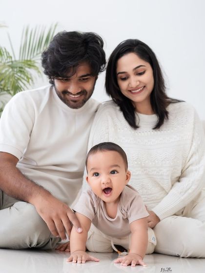 A family of three, with the baby crawling in front.