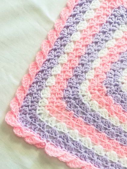 A corner detail of the pink and purple granny square blanket, focusing on the delicate scalloped edge. It's these small details that make a handmade item so special.