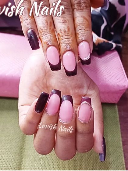A dark, vampy French manicure with deep brown tips and a subtle silver glitter line.