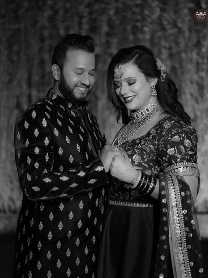 Another shot from the same black and white series, focusing on a quiet, connected moment. This composition highlights the couple's hands and expressions.