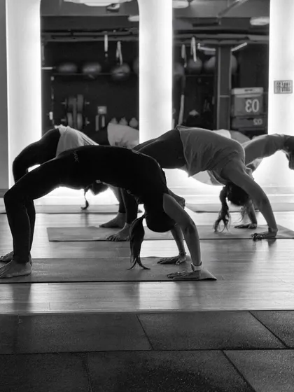 A class full of students practicing the Wheel Pose together. This image captures the collective strength and determination that defines our community.