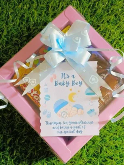 A sweet 'It's a Baby Boy' gift box, perfect for sharing your happiness. This simple yet thoughtful hamper includes a personalized card and a selection of treats, all tied up with a lovely blue bow.