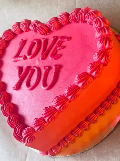 A vibrant heart-shaped cake with an ombre red and pink design. The "Love You" message makes it a perfect, straightforward expression of affection.