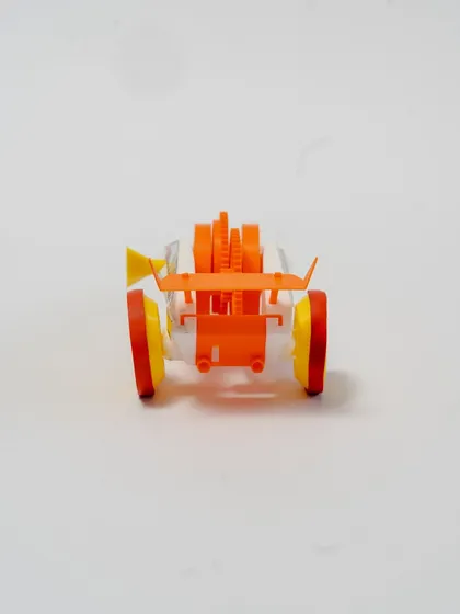 The rear view of the wind-up car, highlighting the spoiler and wheel assembly.