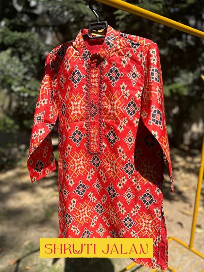 This vibrant red kurta features a traditional ikat-style print. It’s a bold and stylish choice for any little boy who loves to stand out.
