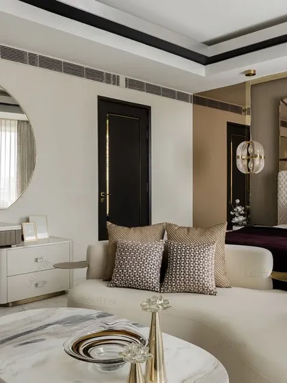 A view of the master bedroom's lounge and vanity area. The round mirror and fluted dressing table complement the room's curves, while the deep plum and neutral tones create a sophisticated and restful palette.