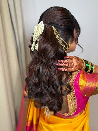 A view of the beautiful, traditional hairstyle. The soft waves and floral accessories are the perfect complement to the bride's elegant makeup.