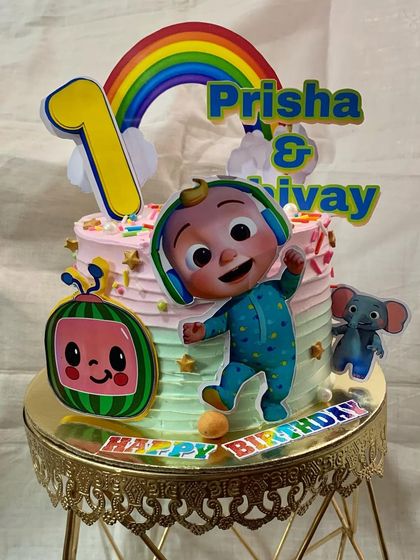 A colorful Cocomelon cake celebrating a joint first birthday for Prisha and Shivay.