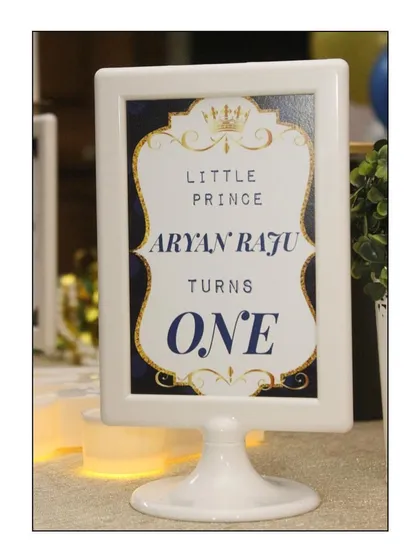 Personalization is key. For Aryan's prince-themed party, we created this custom-framed sign that reads 'Little Prince Aryan Raju Turns ONE', adding a formal and regal touch to the decor.