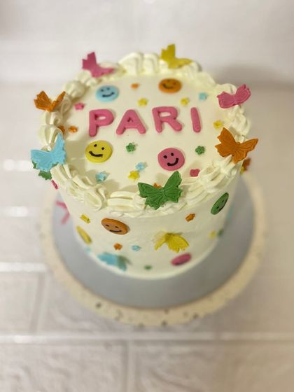 Another perspective of the delightful smiley and butterfly cake.