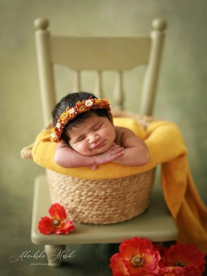 Another angle from this sunny session. The focus here is on the baby's sweet expression and the beautiful textures of the basket and wrap, creating a timeless and artistic image.