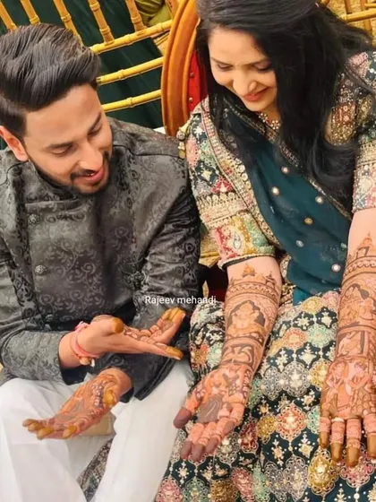 A beautiful moment with the happy couple showing off their mehendi. I design the groom's henna to complement the bride's, creating a cohesive look for your wedding photos.