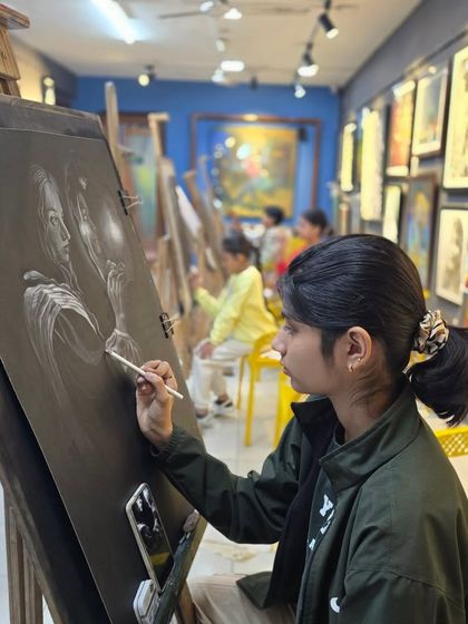 A student works on her charcoal drawing during a busy class. Our studio is always buzzing with creative energy, with easels set up for everyone to work comfortably.