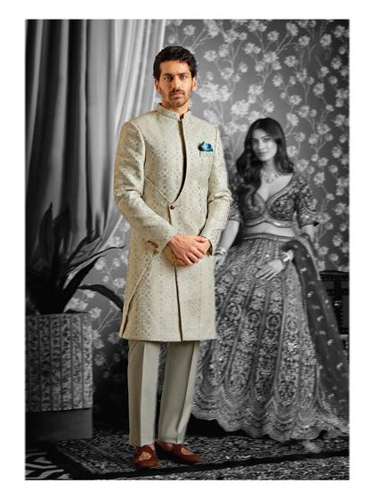 A portrait of elegance. The groom's off-white asymmetrical sherwani provides a striking yet harmonious contrast, showcasing a modern approach to wedding attire.