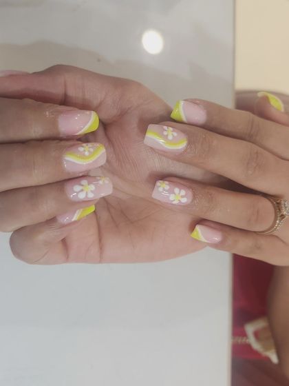 A sunny and cheerful design with yellow French tips and swirls, accented with hand-painted white daisies.