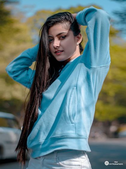 A clear, beautifully lit portrait from the blue hoodie series, capturing a sweet and direct look from the model.