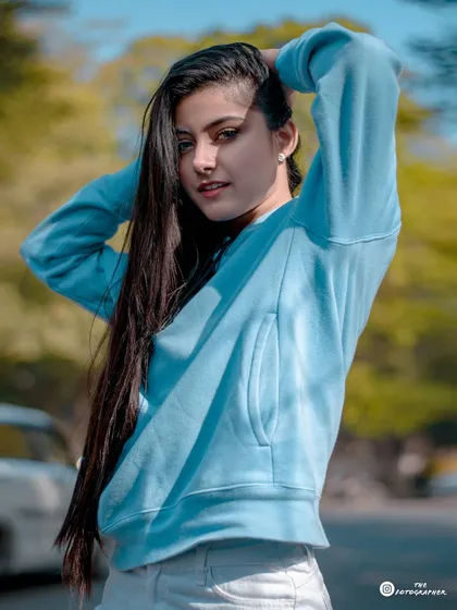 A clear, beautifully lit portrait from the blue hoodie series, capturing a sweet and direct look from the model.