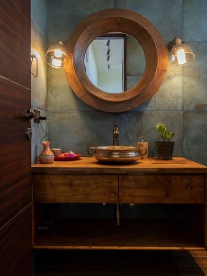 A rustic yet refined bathroom from our Nandi Hills project. The design features a chunky wooden vanity, a hammered metal sink, and a thick wood-framed mirror, all contributing to a warm, earthy aesthetic.