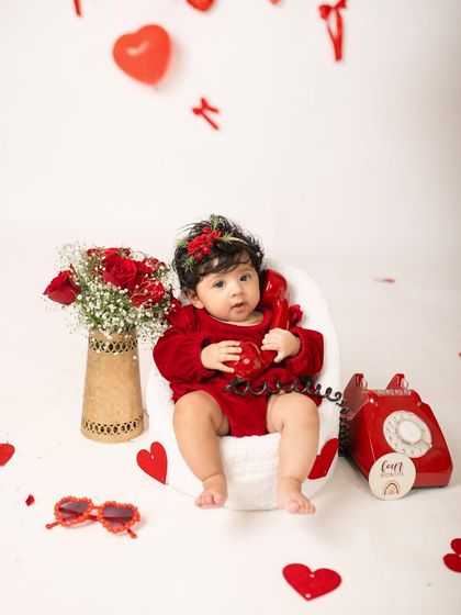 This little one is ready for her close-up during her four-month Valentine's photoshoot, complete with a vintage red telephone prop.