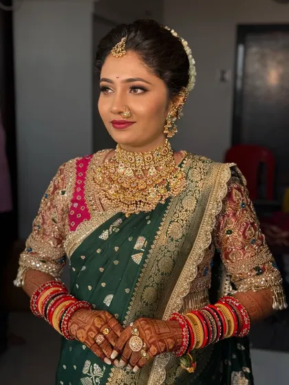 Another angle of the bride in her green Paithani, showing her radiant smile.